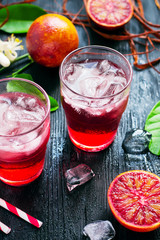 Citrus refreshing cocktail with ice and red oranges