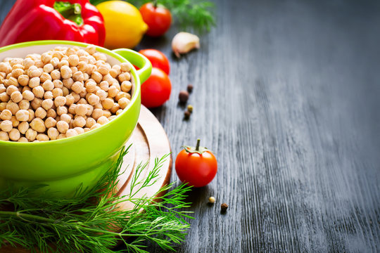 Background with chickpeas and colorful vegetables, space for tex