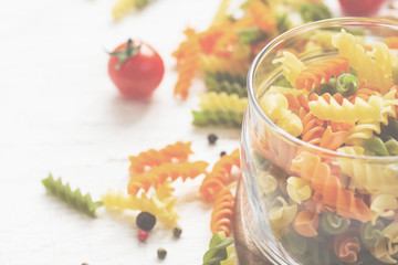 Raw colorful italian fusilli pasta and spices, tinted, selective