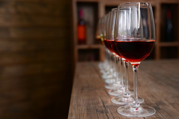 Many glasses of different wine in a row on bar counter