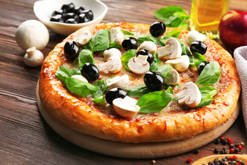 Delicious tasty pizza with ingredients on wooden table