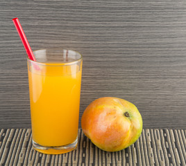 Mango juice and fresh mango on a dark wood background. tinting. selective focus