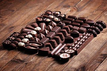 Delicious chocolate candies on wooden background