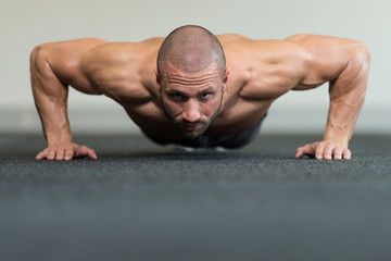 Healthy Man Doing Press Ups In Gym