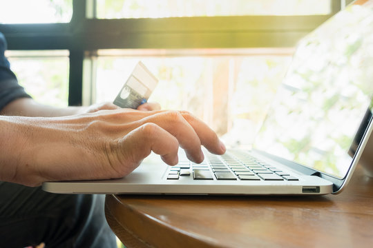 Online payment,Man's hands holding a credit card and using lapto
