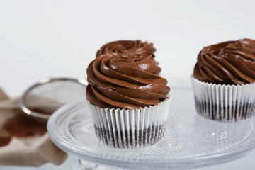 Chocolate cupcakes on light glass background, close up