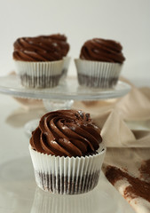 Chocolate cupcake on light glass background, close up
