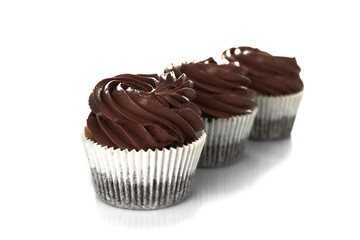 Three chocolate cupcakes, isolated on white