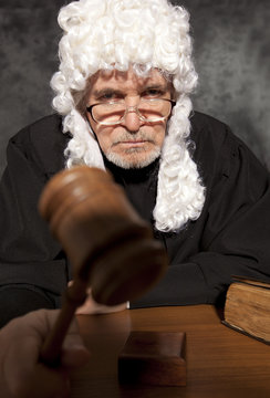  Old male judge in a courtroom striking the gavel
