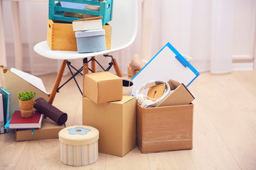 Cardboard and wooden boxes with things for relocation in room interior