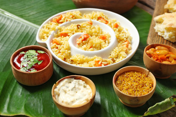 Fried rice with vegetables and spices on banana leaf background
