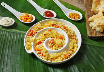 Fried rice with flat bread and spices on banana leaf background