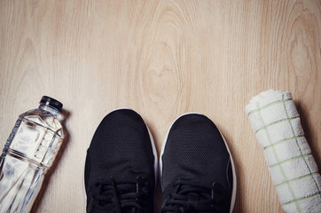 Sport equipment, Sneakers, water, towel on wooden background, Flat lay
