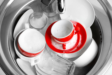 Pile of dishes in sink closeup