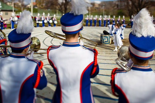 rear view of men in uniform playing trumpet.
