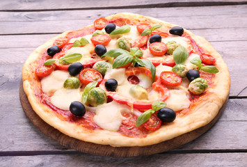 Delicious pizza with cheese and vegetables on wooden background