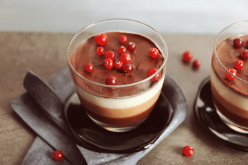 Delicious dessert with rowan in glass on table