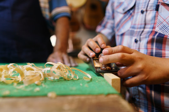 Boy Learns Crafting Wood In Lute Maker Shop