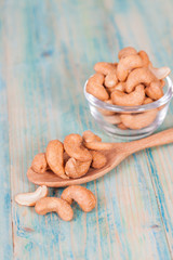 Cashew nuts in spoon, on the wooden
