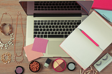 Laptop and female accessories on wooden table, top view
