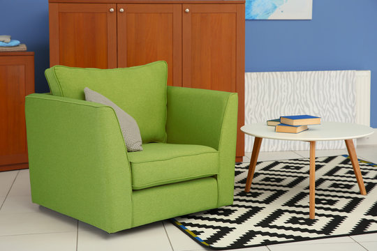 Green armchair in modern interior of living room