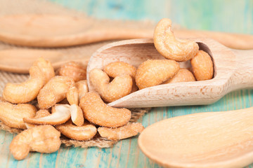 cashew nuts in spoon on wood arrange on white