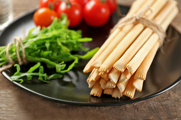 Bread sticks with arugula and cherry tomatoes on plate