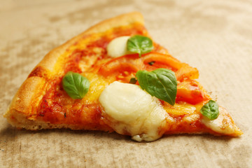 Margherita pizza slice on cardboard background