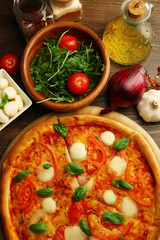 Margherita pizza with tomatoes, basil and Mozzarella on wooden background