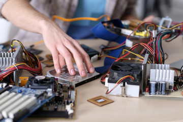 Young man repairing computer hardware in service center