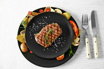 Delicious grilled steak with vegetables on plate