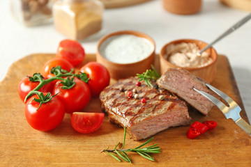 Delicious grilled steak on cutting board, closeup