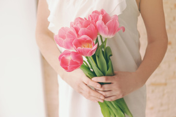 Woman holding a fresh bouquet of tulips.