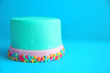 Birthday cake with sprinkles on blue background.