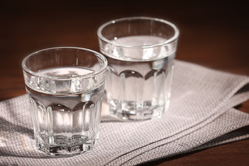 Glasses of water with napkin  on wooden background