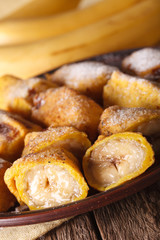 Fried bananas in batter on a plate closeup. vertical