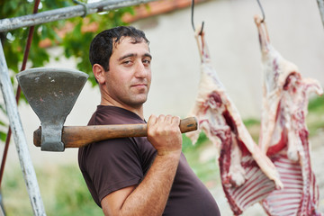 butcher with axe and sheep carcass meat
