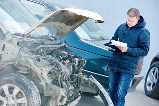 Insurance Agent Recording Car Damage On Claim Form