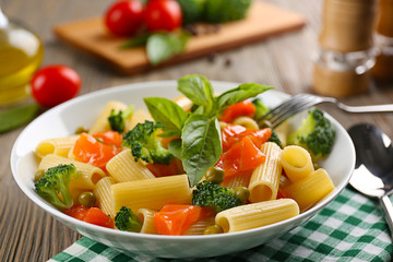 Plate of pasta with salmon and broccoli on table closeup