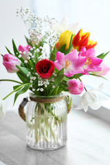 Bouquet of beautiful colorful tulips in glass vase on windowsill, indoors