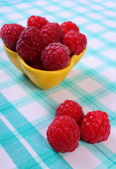 Fresh raspberries on checkered tablecloth, healthy food