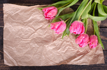 Beautiful bouquet of pink tulips on craft paper. Free space for your text.