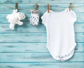 Fototapeten Baby boy clothes and white bear toy on a clothesline © dash1502