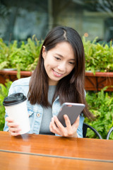 Woman use of mobile phone at outdoor cafe