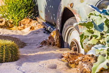 carcass of an old rusty car in the desert