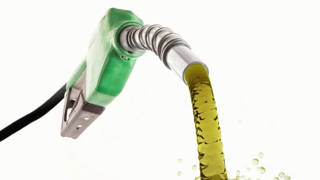 Fuel flowing from a green nozzle on white background in slow motion