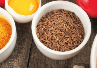 cumin seeds in white bowl with foodstuffs