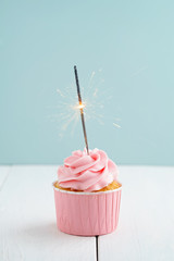 Pink buttercream cupcake with sparkler for a party or birthday