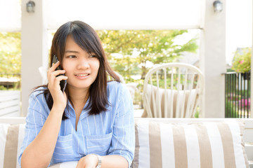 Obraz premium Young woman talking on the phone in a cafe. Selective focus.
