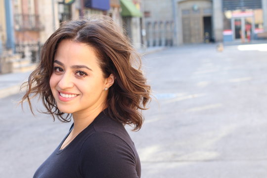 Portrait of a young Hispanic female smiling with copy space on the right side of the picture